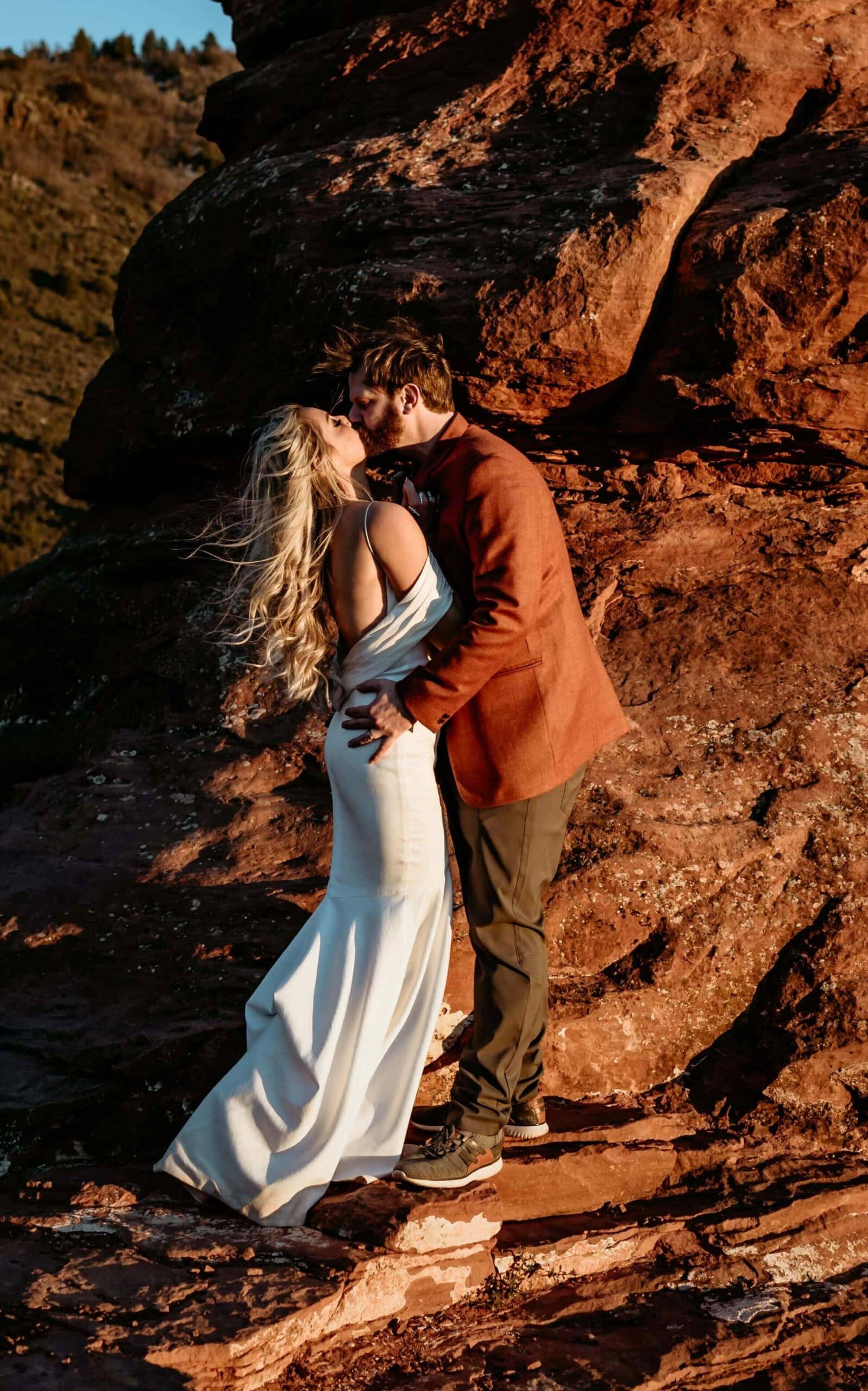 Bride and groom in a windblown kiss embrace during their Sedona elopement