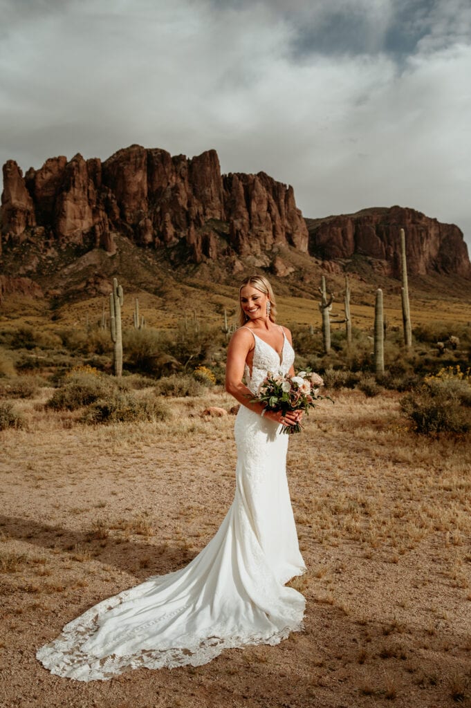 Bride with pink and cream bouquet at the foot of the Superstition mountains in Arizona during her elopement