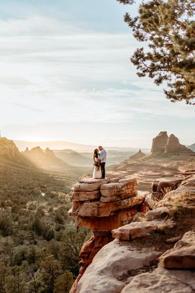 A dramatic kiss at Merry go Round Rock in Sedona, Arizona by a sweet elopement couple taken by Arizona Elopement Photographer Shannon Durazo who hikes with couples to take epic photographs