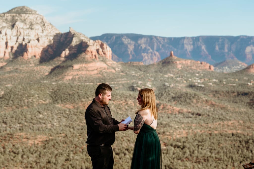 Groom reading vows overlooking the canyons of Sedona AZ