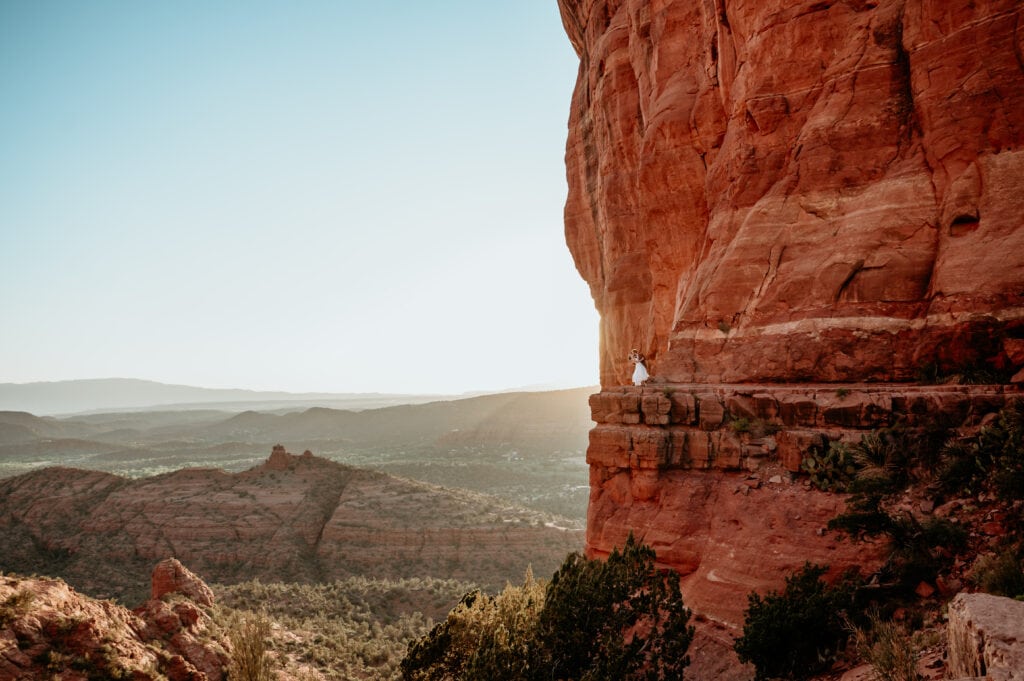 Couple dancing on the ledge of a giant red rock tower while eloping in Sedona