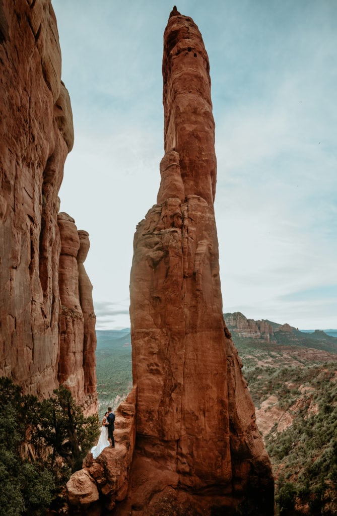 Couple standing on secret red rock spire during their Sedona Elopement