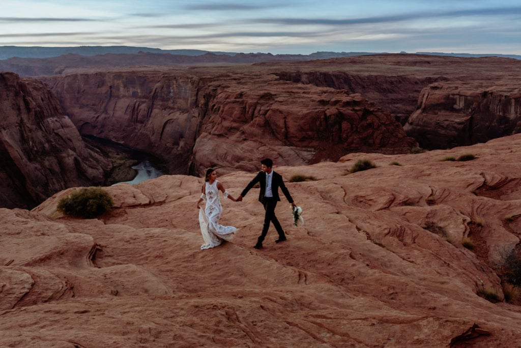 Bride leads groom along the red sandstone at Horseshoe Bend in Page, Arizona