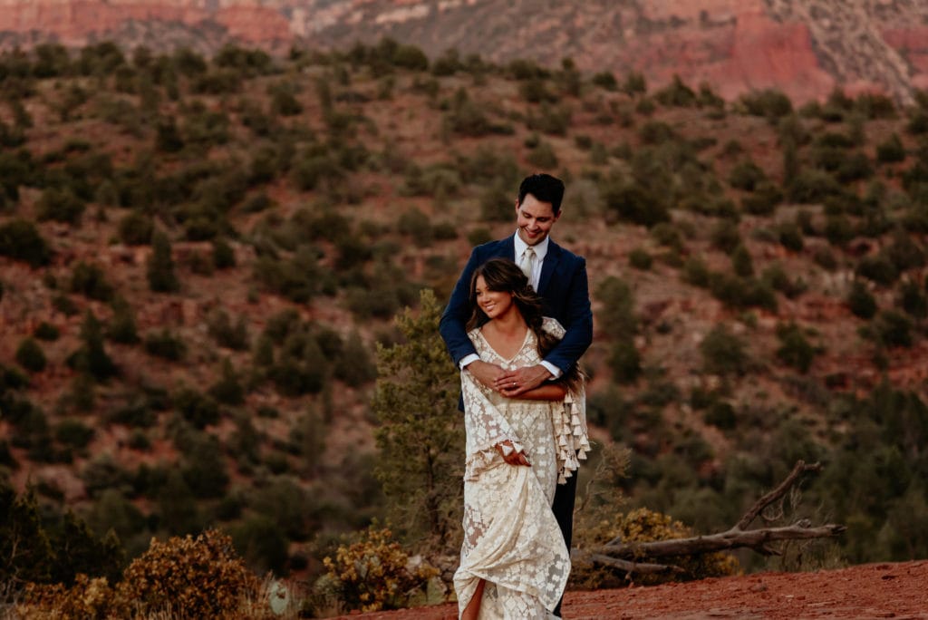 Couple embrace surrounded by Sedona red rocks
