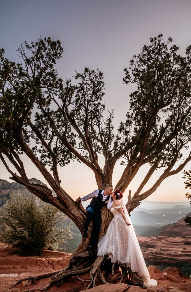 Couple kissing in the secret Sedona heart tree up Merry Go Round Rock in Arizona