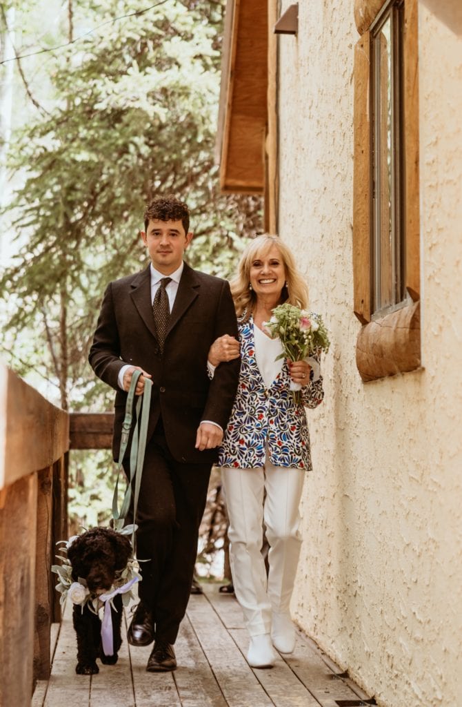 Mother and brother of the bride walk down the isle with doggy flower girl