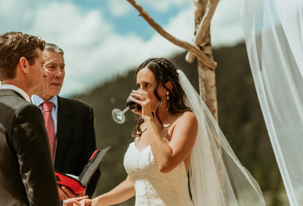 Liz sipping wine during the traditional Jewish seven blessings during their Lake San Cristobal wedding