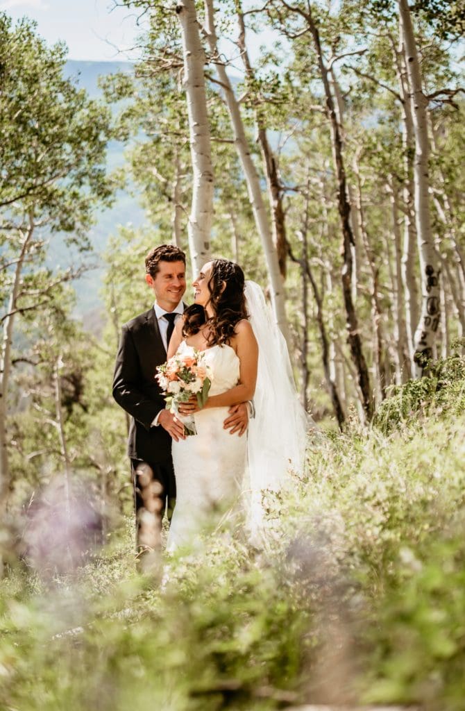 Colorado elopement couple surrounded by wildflowers and aspen trees