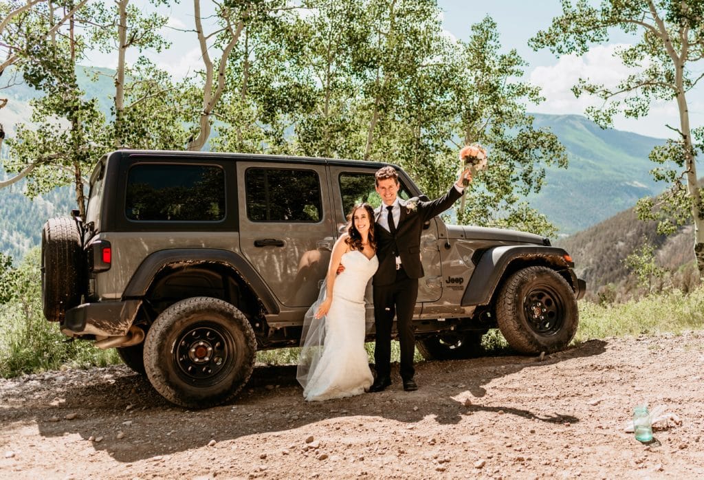 Elopement couple celebrating with their jeep during their offroad elopement adventure