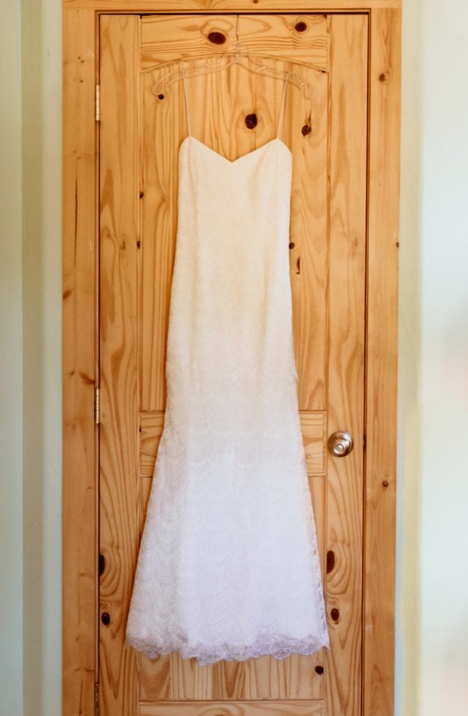 Wedding dress hanging on a wood door in a Colorado mountain cabin