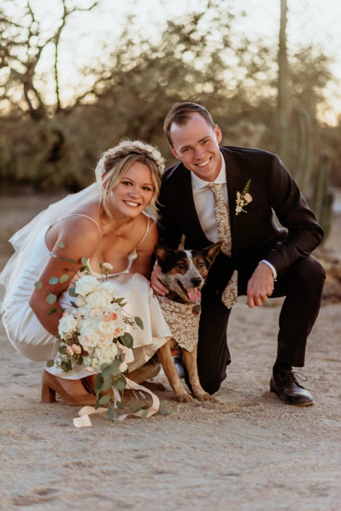 Couple and their doggy flower girl Kyote smiling