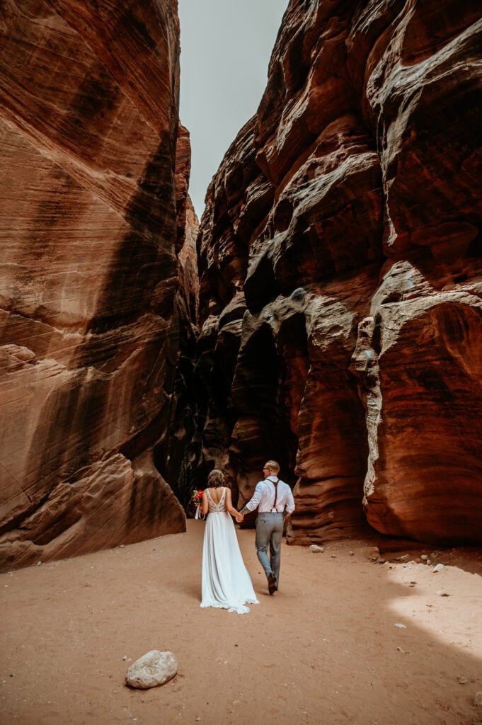 Couple walking into slot canyons in Southern Utah