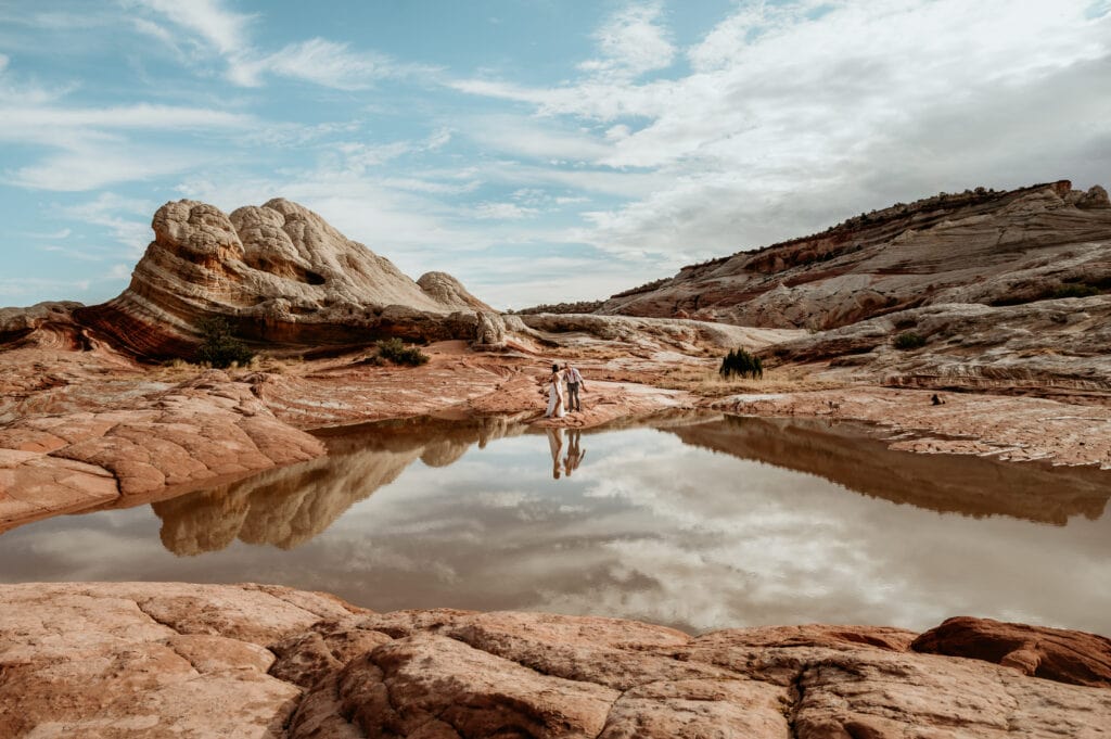 Couple standing at the edge of a puddle reflection during their Arizona elopement