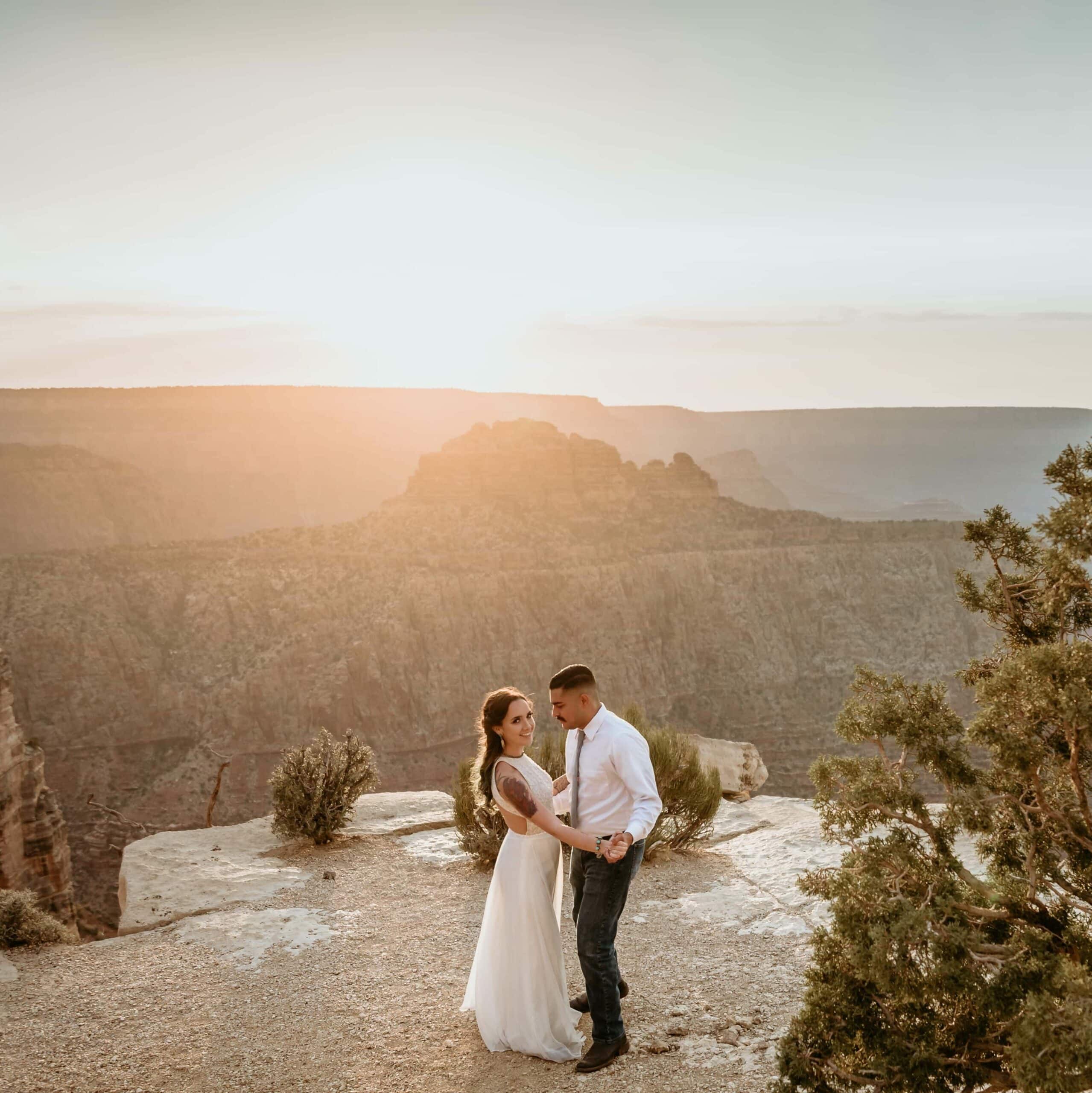 Bride and groom who chose an elopement package instead of a big wedding dancing at the edge of the Grand Canyon at sunset