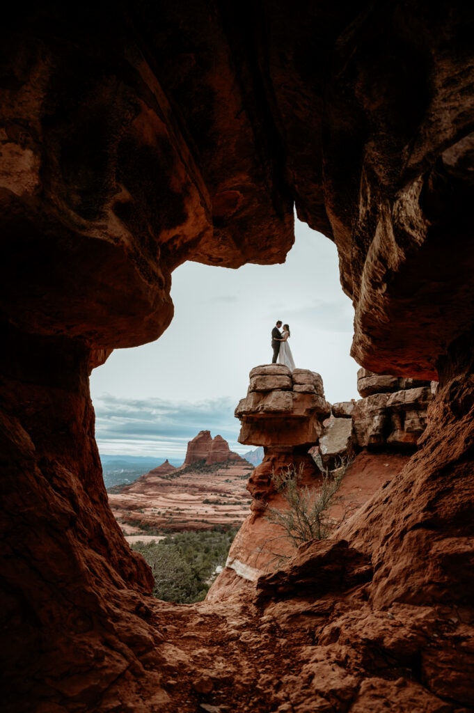 Couple standing on a red rock ledge during their Sedona elopement