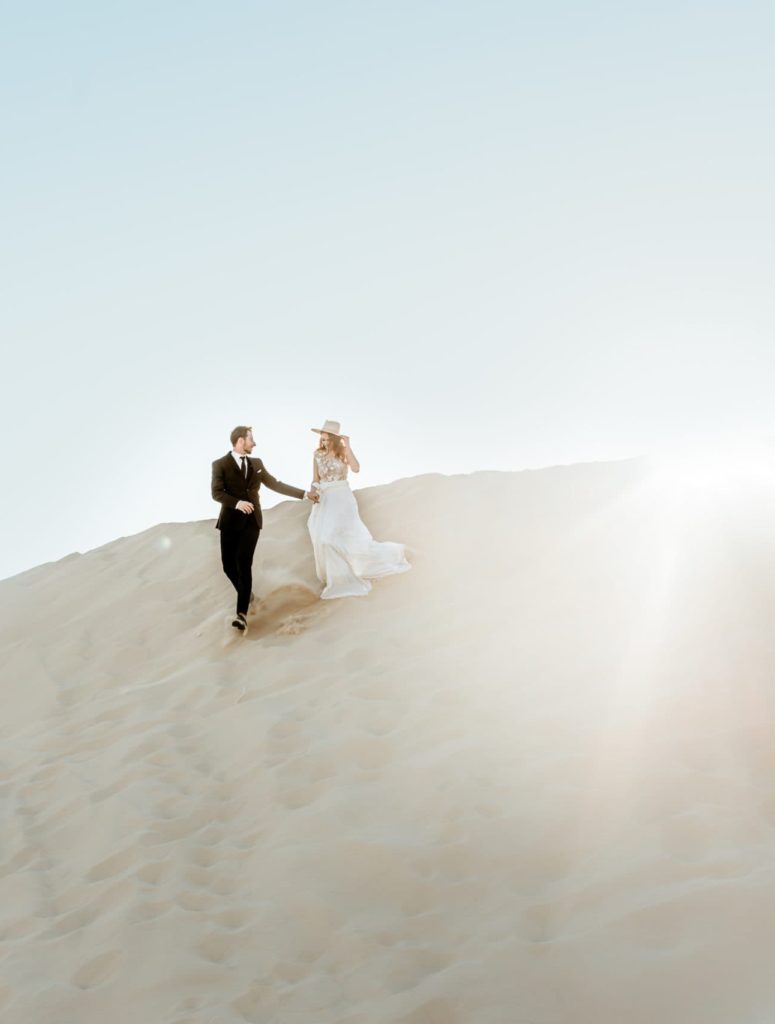 Couple running down sand bank by Arizona Elopement Photographer Shannon Durazo.