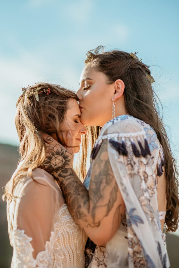 Bride kisses partner's forehead during Sedona elopementg