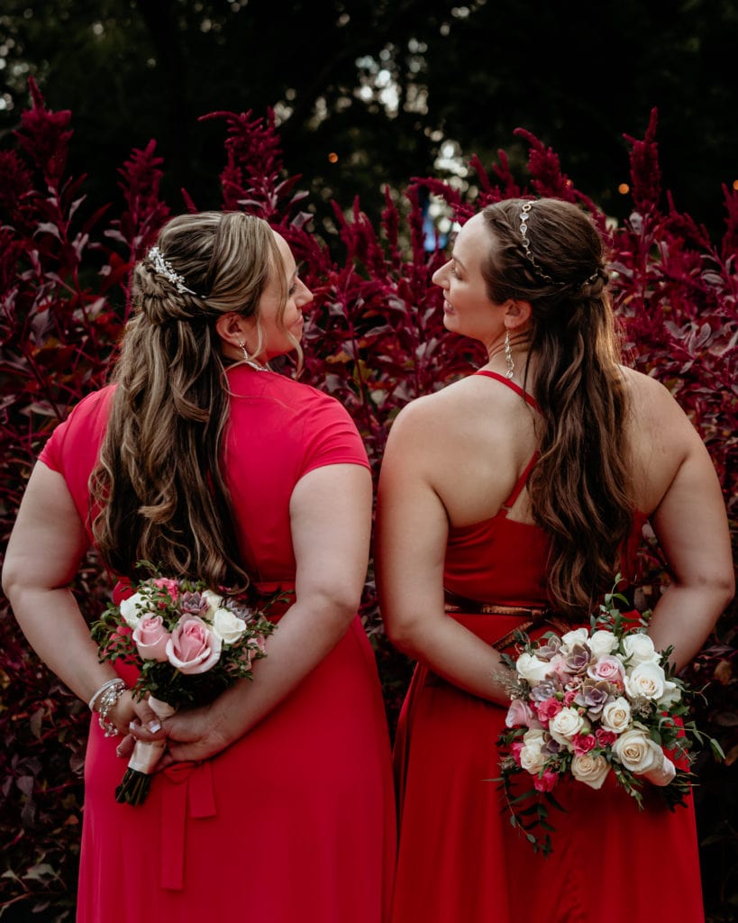 Bride and bridesmaid show succulent bouquets and beautiful long hair